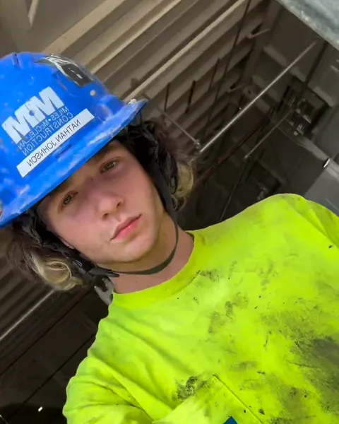 Nathan Johnson in a hard hat and hi-vis shirt on a construction site