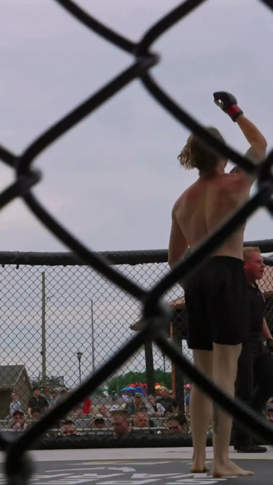 Nathan Johnson raising his fist, seen from behind through the cage fence, LFS Middletown Mayhem, Jul 11, 2026